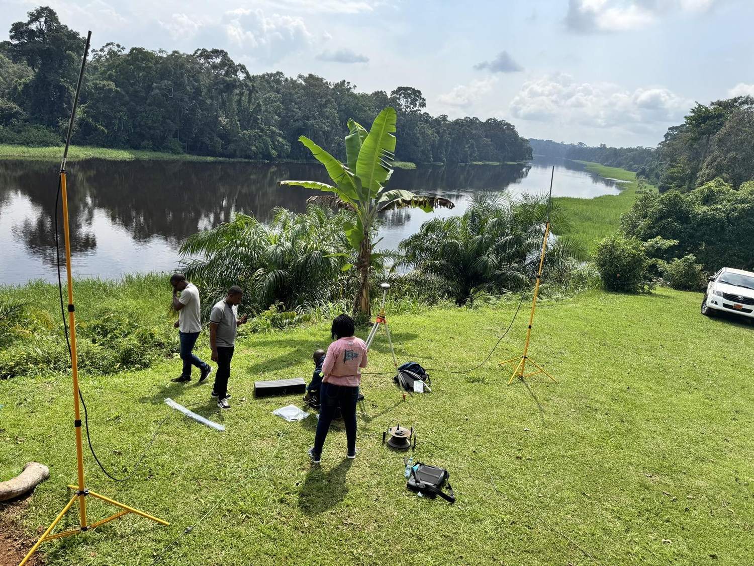 Nexxis surveyors setting up a GNSS control survey beside a river in Ghana